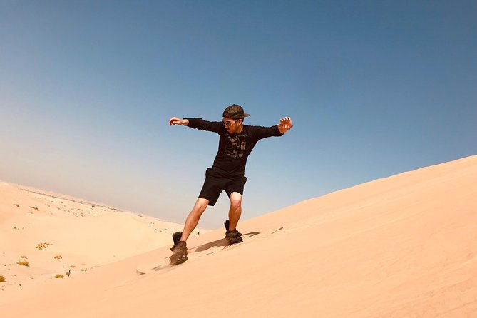 Abu Dhabi Morning Desert Safari,Dune Bashing,Sandboarding,Camel Riding&Quad Bike - Sandboarding on a high dune
