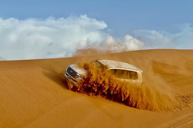 Dubai Desert Safari: Dune Bashing, Camel Ride, Sandsurf & 5<em> BBQ – Key points at a glance’ /></p>
<ul>
<li><strong>Lahbab’s red dunes:</strong> The desert setting is more dramatic than a short sand ride near the city, with time for a photo stop and sandboarding.</li>
<li><strong>Dune bashing in a 4×4:</strong> The main thrill lasts a substantial part of the first stop, though it can feel rough if you are prone to motion sickness.</li>
<li><strong>Useful cultural touches:</strong> Camel feeding, Arabic attire, henna, dates, gahwa, falcon photos, and a Bedouin-style camp add more than a simple off-road ride.</li>
<li><strong>Dinner and entertainment included:</strong> You get a barbecue buffet with vegetarian and non-vegetarian choices, plus Tanoura, belly dance, fire show, and Ladies Khaliji Dance.</li>
<li><strong>Shared transport and camp:</strong> Pickup is convenient, but the vehicle and camp are shared, with capacity for as many as 100 people.</li>
<li><strong>Low headline price:</strong> At about $27.91 per person, the package covers a lot, but quad bikes, shisha, alcohol, and VIP seating cost extra.</li>
</ul>
<h2>From Dubai hotels to Lahbab’s red dunes</h2>
<p><img width="669" height="446" decoding="async" src=