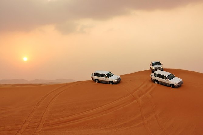 Dubai Desert Safari with BBQ Dinner, Camel Ride, and Shows - Sandboarding and the sunset photo stop