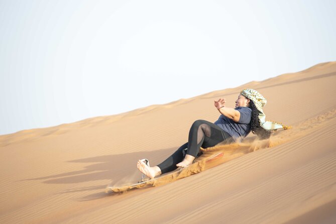 Dubai Half-day Red Dunes bashing with Sandboarding, Camel &Falcon - Sandboarding after the vehicle ride