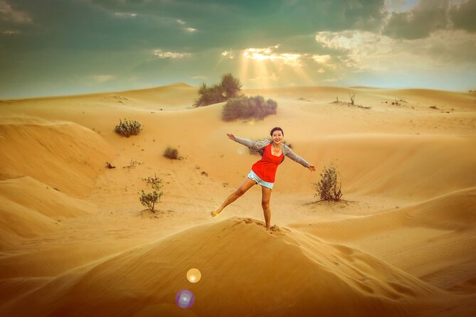 A sandboarder on a red dune outside Dubai in the last hour of light