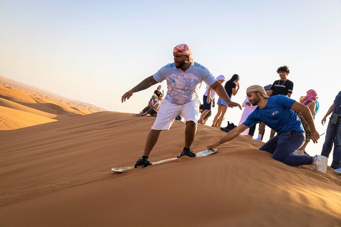 Dubai Red Dunes with Sandboarding, Camel Ride, Falcon & VIP Camp - Sandboarding on a high dune