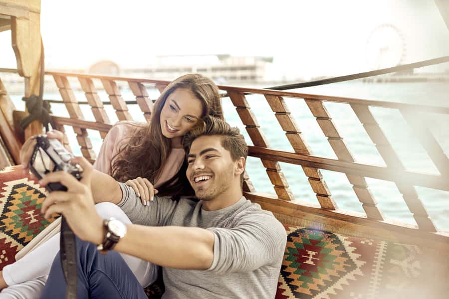 Dubai: Sunset Cruise on Traditional Boat & Emirati High Tea - A wooden Abra beneath Dubai’s modern skyline