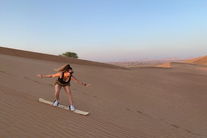 Morning Desert Safari, Quad Bike, Sandboard and Camel Ride - Quad biking in a fenced desert area